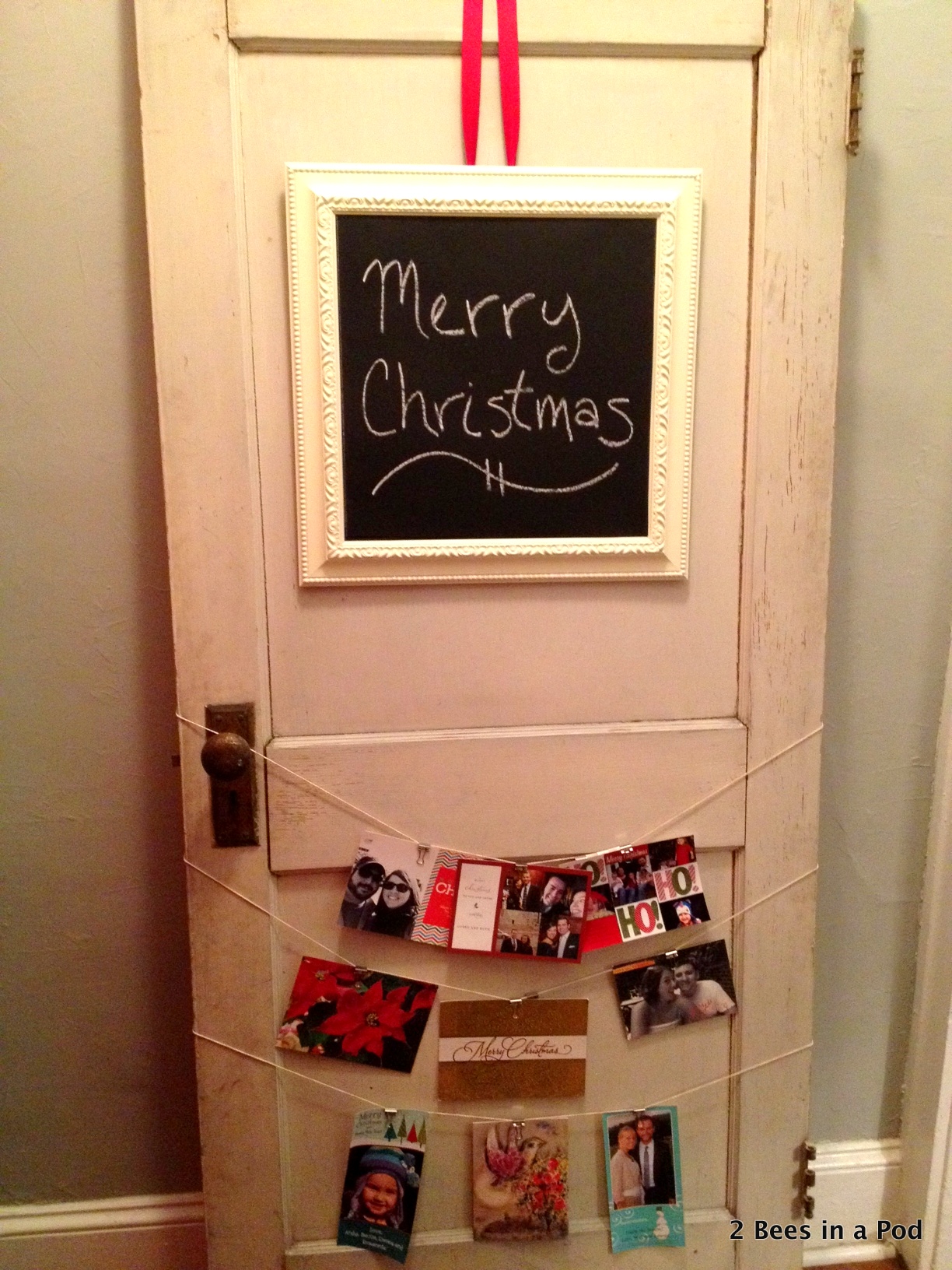 Christmas card holder with chalkboard with ribbon and twine to hold cards.