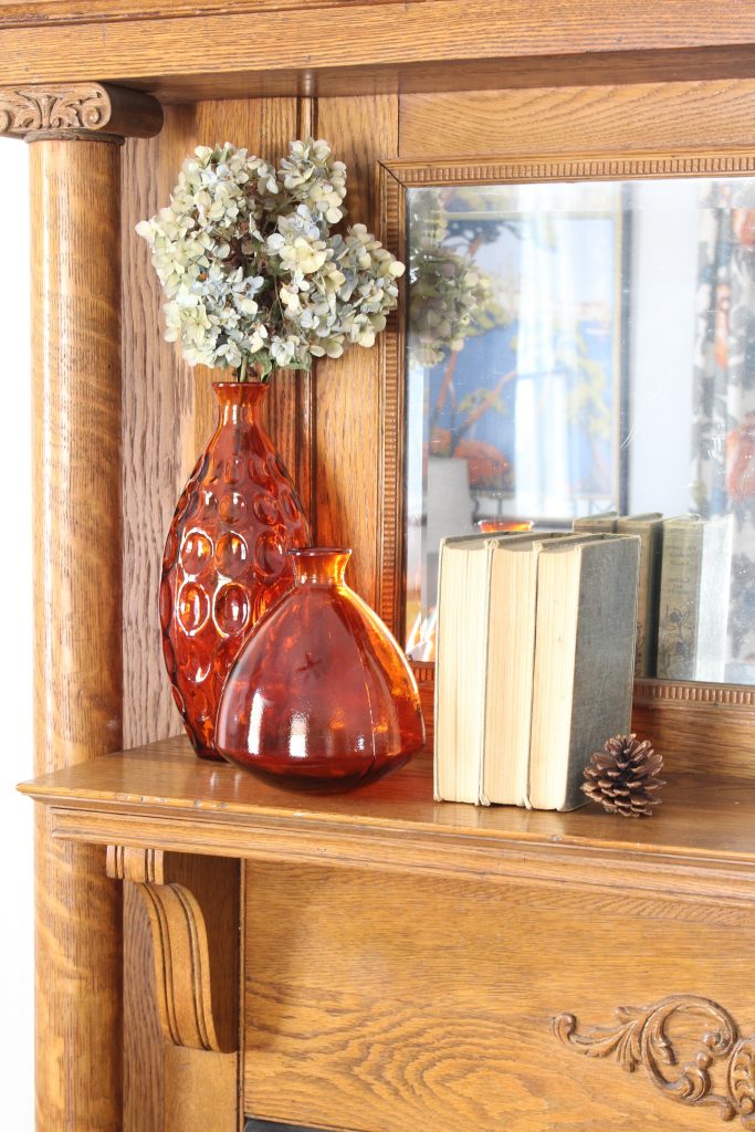 Fall mantel decor with orange glass bottles. Fall home decor.