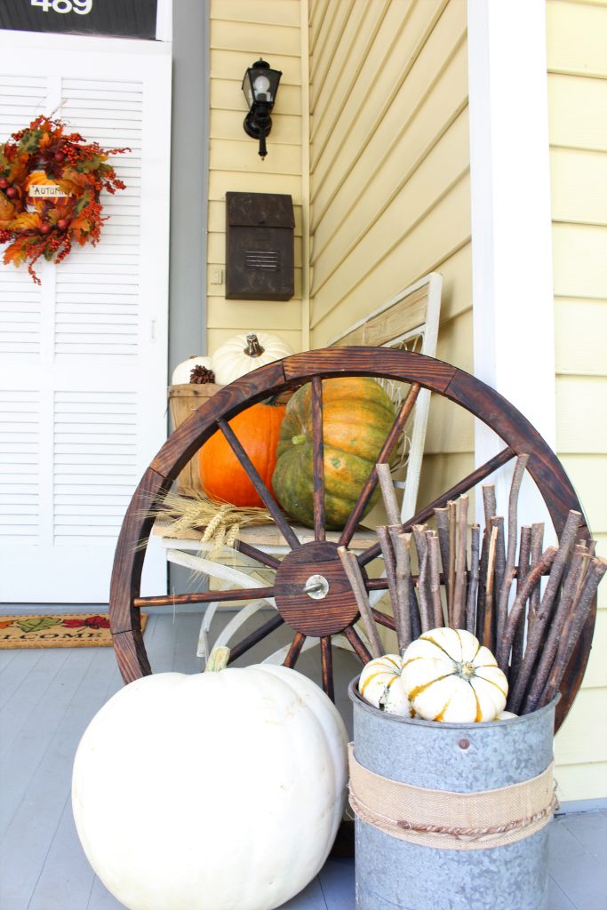 Rustic wagon wheel and white pumpkins for Fall front porch.s