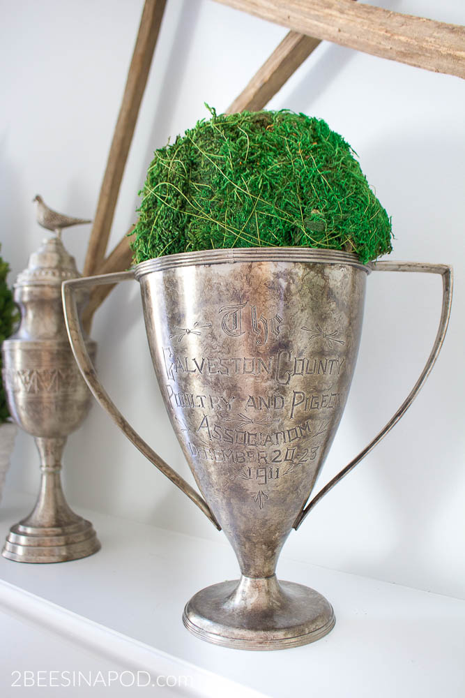 Hello Spring Mantel. Two vintage trophies with green moss ball for spring mantel.