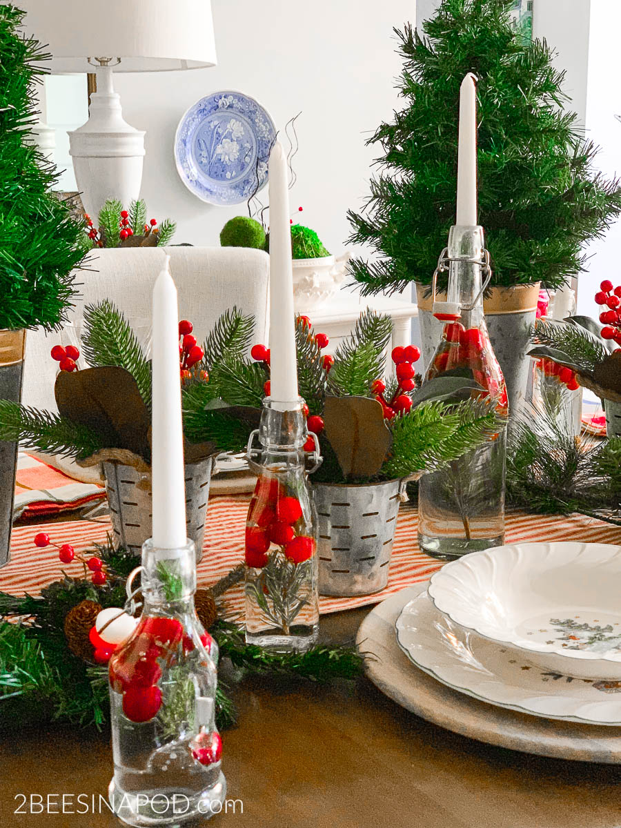 Festive Christmas centerpieces arrangement with candles, ornaments, and greenery